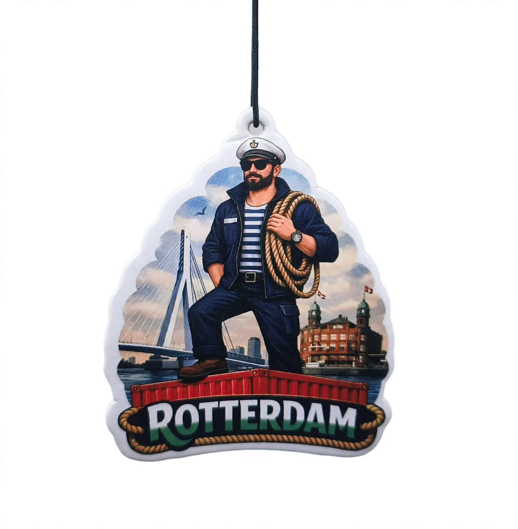 Workscent - Port Of Rotterdam autogeur. Deze werkgeur laat een stoere Rotterdamse matroos staand op een container zien met op de voorgrond het woord Rotterdam in  groen/wit. Op de achtergrond vind je een helder blauwe lucht met Rotterdamse iconen als Hotel New York, het Poortgebouw en de Erasmusbrug. Dit is een must voor diegene die hele dag op de weg zitten. 